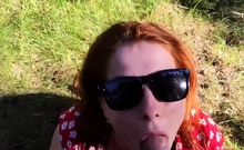 Kinky redhead with big tits gives a blowjob outdoors